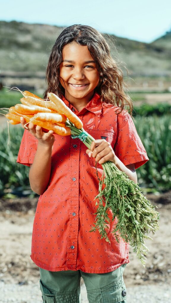 young boy holding carrots
